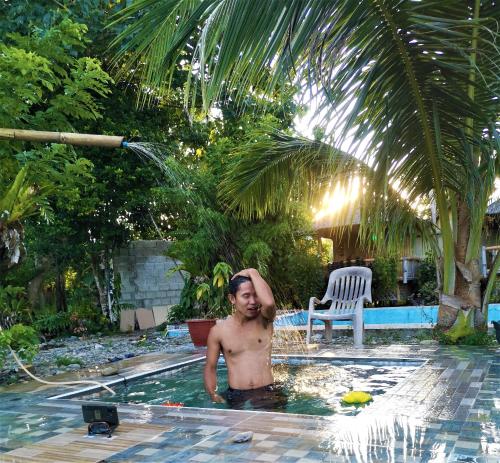 a shirtless man standing in a swimming pool at Villa Catalina Bora 3 Resort in Nabas