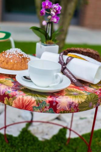 a table topped with a cake and a cup of coffee at Point Hotel in Piove di Sacco