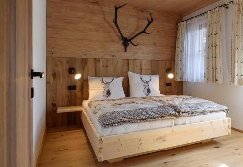 ein Schlafzimmer mit einem Bett mit einer Uhr an der Wand in der Unterkunft Chalet Seeklause in Bad Goisern