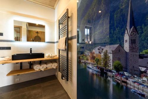 a bathroom with a sink and a painting on the wall at Chalet Seeklause in Bad Goisern