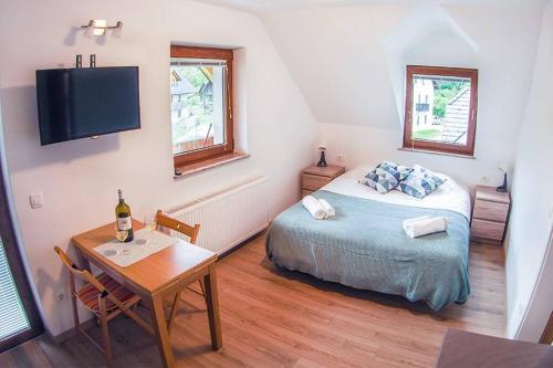 a bedroom with a bed and a table and a tv at Place of Wonder in Bohinj