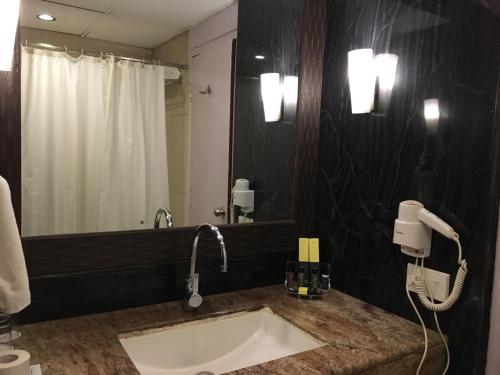 a bathroom with a sink and a mirror at Accord Highland Hotel Ooty in Ooty