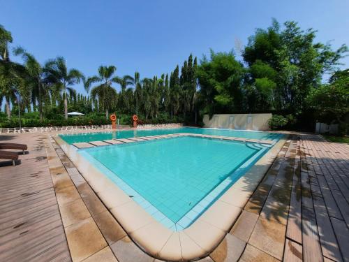 a swimming pool in a resort with trees at Estancia De Lorenzo Tarlac in Tarlac