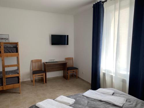 a bedroom with a bed and a desk and a television at ZIG ZAG in Kamianets-Podilskyi