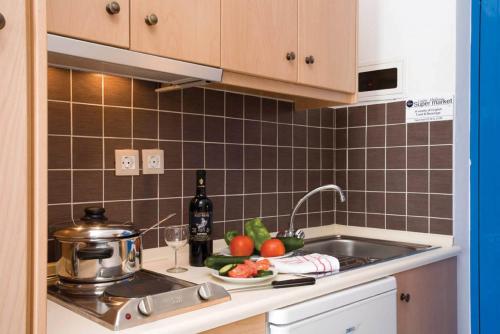 a kitchen counter with a sink and a plate of food at Pefki Islands in Pefki