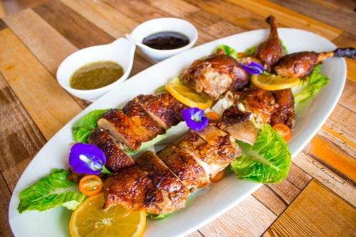 a plate of food with chicken and vegetables on a table at Estancia De Lorenzo Tarlac in Tarlac