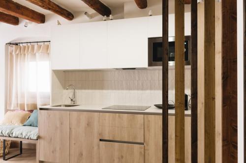 uma cozinha com armários de madeira e um lavatório em Apartaments la Rambla - Esperó de Bolós - 4 pers em Cornudella