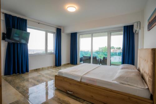 - une chambre avec un lit et une grande fenêtre dans l'établissement HOME for FOUR, à Mamaia Nord – Năvodari