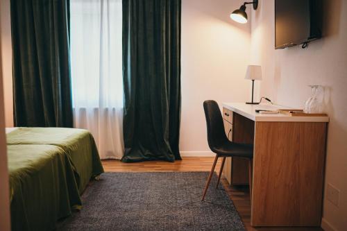 a bedroom with a desk and a bed and a window at Nest Guesthouse in Drobeta-Turnu Severin