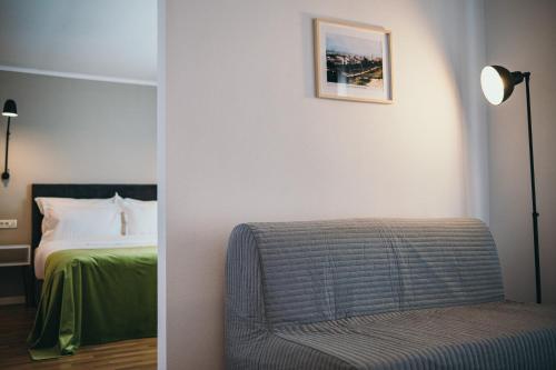 two pictures of a bedroom with a bed and a chair at Nest Guesthouse in Drobeta-Turnu Severin