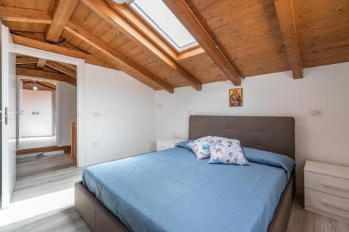 a bedroom with a bed with blue sheets and a skylight at Mary House in Carloforte
