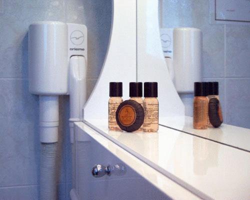a bathroom with three bottles of hair products on a shelf at Hotel Beau Sejour in Etroubles