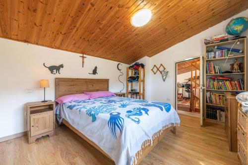 una camera con letto e soffitto in legno di Casa Ewa a Carloforte
