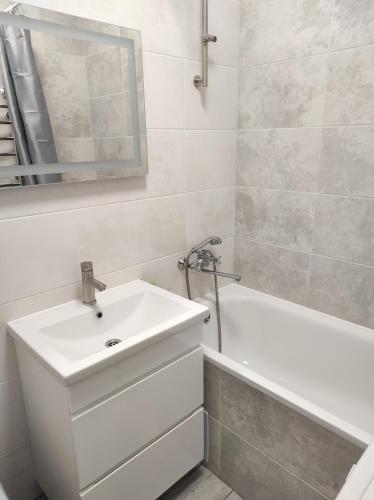 a white bathroom with a sink and a bath tub at 2 комнатная с новым ремонтом, кондиционером, в самом центре in Rivne