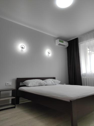a bedroom with a bed with two lights on it at 2 комнатная с новым ремонтом, кондиционером, в самом центре in Rivne
