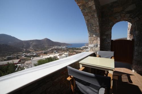 a balcony with a table and chairs and a view at Skopelitis Village in Katapola