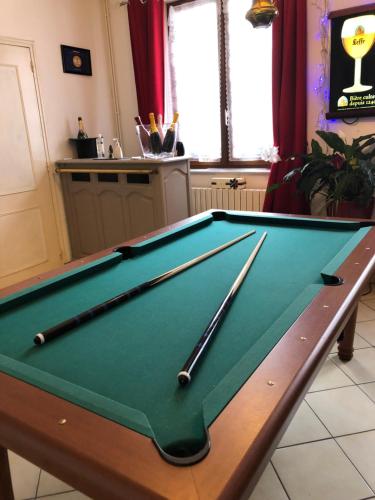 a pool table with cuesticks on top of it at La Petalerie in Épernay