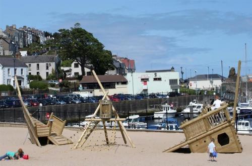 two children playing on a playground on the beach at Home Sweet Home in Ballycastle