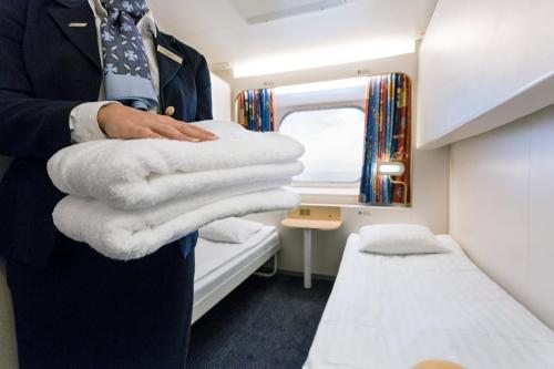 a man in a suit and tie holding a pile of towels at DFDS Ferry - MiniCruise Copenhagen to Oslo in Copenhagen