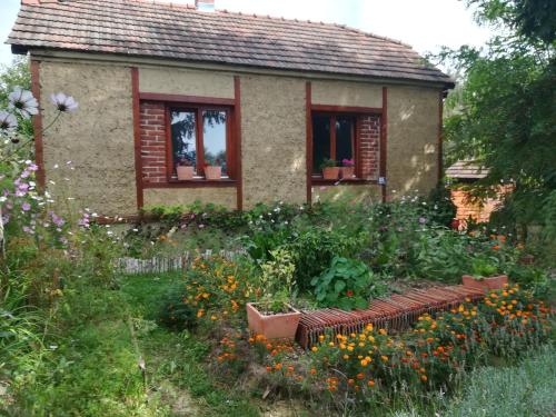 a garden in front of a small house with flowers at Ruralna kuća za odmor Pozojova hiža - Rural Holiday House in Lopatinec