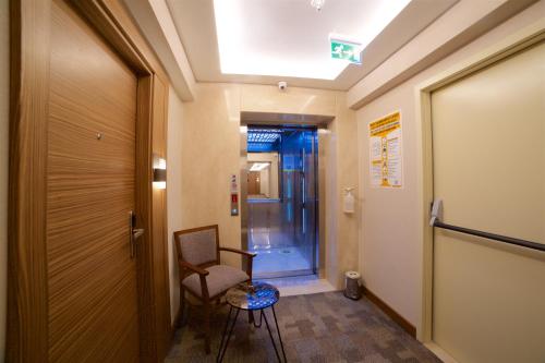 a hallway with a chair and a door to a room at Erboy Hotel Istanbul Sirkeci in Istanbul