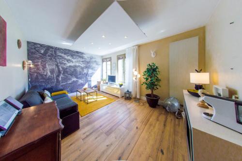 un soggiorno con un divano e un tavolo di RétroMirabeau "Le Raspaïl" - 65m2 avec VUE - 2 CHAMBRES - 4 pers - COURS MIRABEAU HALLES GARE - EMPLACEMENT TOP - Chèques Vacances CONNECT a Narbonne