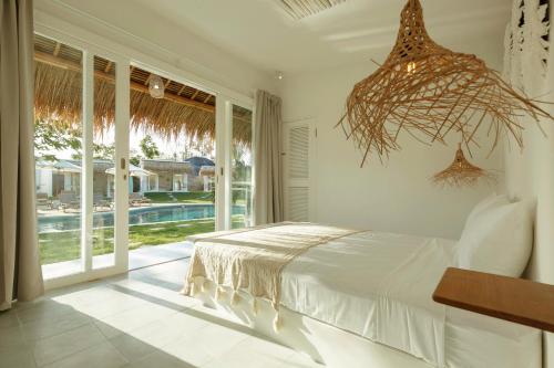 a bedroom with a bed and a view of a pool at The Bingin Beach Villas' Bungalow Resort in Uluwatu