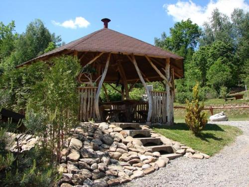 a wooden gazebo with a pile of rocks in front at Domek Rodzynek in Hoczew
