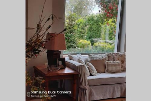 a living room with a couch and a table and a window at Virna s home in Schinias