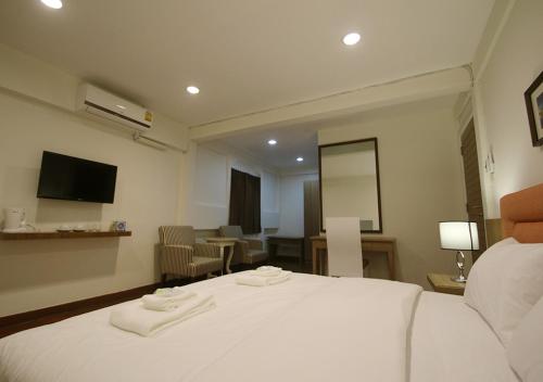 a hotel room with a bed with two towels on it at 09 Hostel Chiangmai in Chiang Mai