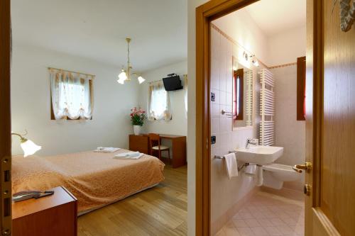 una camera con letto e lavandino e un bagno di Agriturismo Moro Barel a Vittorio Veneto