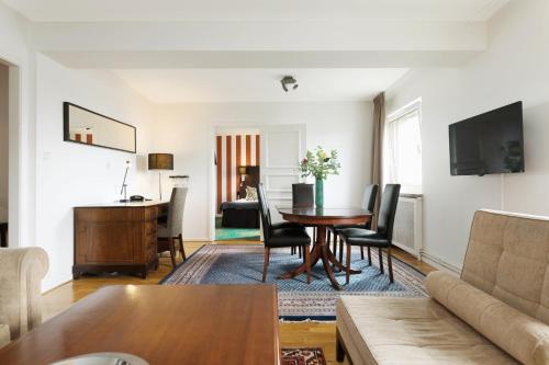 a living room with a table and a couch at ProfilHotels Hotel Garden in Malmö