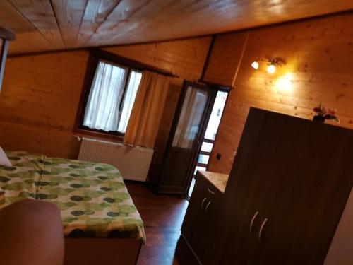 a bedroom with a bed in a room with wooden walls at Cabana David in Beclean
