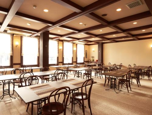 a classroom with tables and chairs in a room with windows at Hotel Cerulean Alpine in Otari