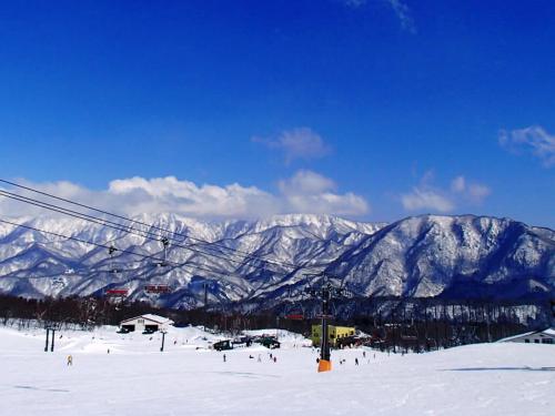 a ski resort with snow covered mountains and a ski lift at Hotel Cerulean Alpine in Otari