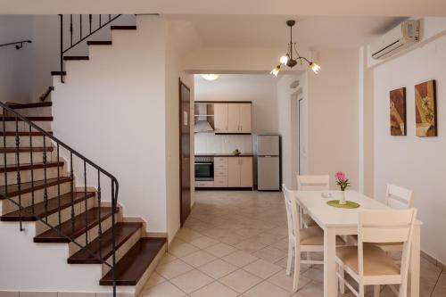 a kitchen with a table, chairs and a refrigerator at Orion Star in Agia Marina Nea Kydonias