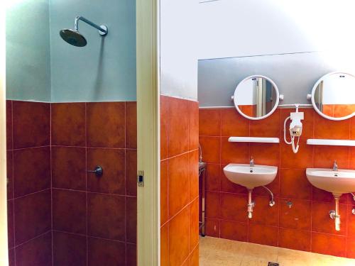 a bathroom with two sinks and two mirrors at Pillow & Bread in Bangkok
