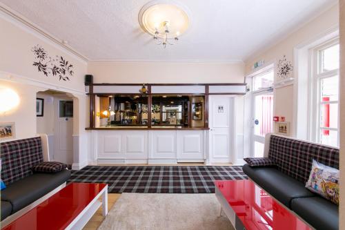 una sala de estar con 2 sofás y un bar en Homeleigh Hotel en Bradford