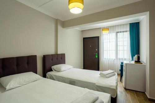 a hotel room with two beds and a window at Vesta Butik Otel in Edremit