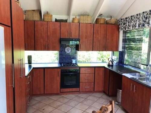 a kitchen with wooden cabinets and a stove top oven at The Gables Guest House in Belfast