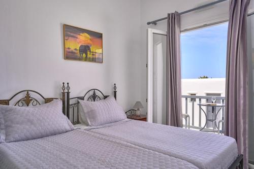 a bedroom with two beds and a balcony at Sofia Village in Mýkonos City