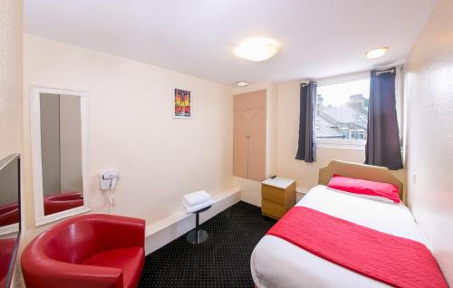 a hotel room with a bed and a red chair at Homeleigh Hotel in Bradford