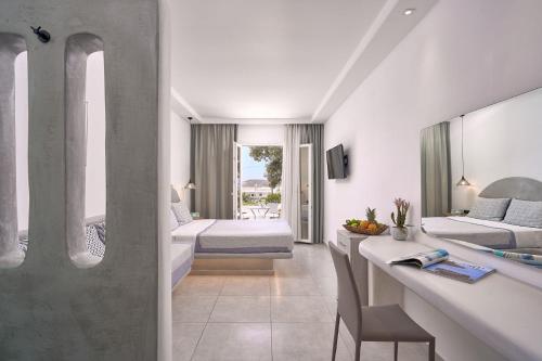 a hotel room with a bedroom and a living room at Sofia Village in Mýkonos City