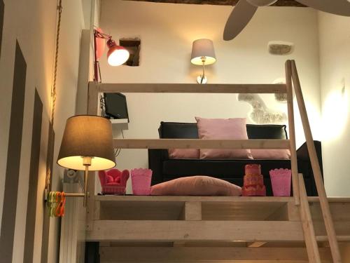 a bedroom with two bunk beds with pink pillows and a lamp at Sanctus Syrus 1 in Albenga