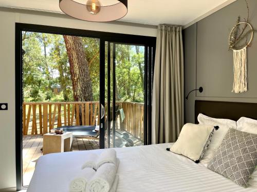 ein Schlafzimmer mit einem Bett und einem Balkon in der Unterkunft Airial du Seignanx in Ondres