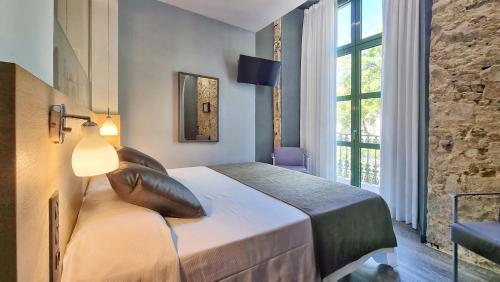 una camera da letto con un letto grande con una grande finestra di Hotel Sant Agustí a Barcellona