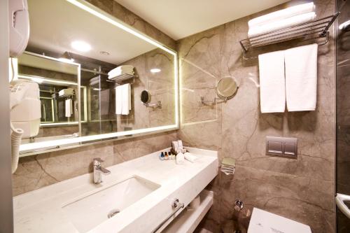 a bathroom with a sink and a large mirror at Erboy Hotel Istanbul Sirkeci in Istanbul