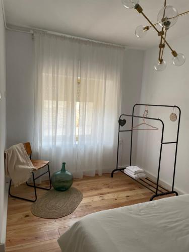 a bedroom with a bed and a vase on a wooden floor at El desván de Bruno in Villalobos