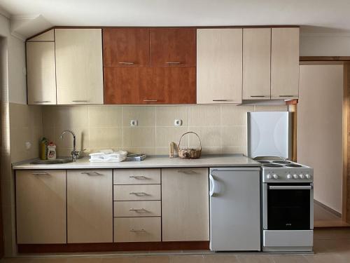 a kitchen with white cabinets and a stove top oven at Apartments Vila Hercegovina in Višegrad