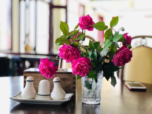 a vase filled with pink flowers sitting on a table at Cat Cat Galerie d’Art in Sa Pa
